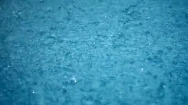 Close-up rainfall, raindrops falling to the surface of the water. Storm. Rain season. — Stockvideo
