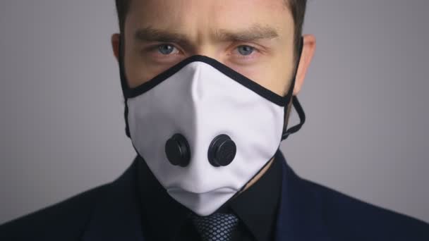 Крупный план портрета бизнесмена в костюме в медицинской маске во время эпидемии коронавируса ковид-19 . — стоковое видео