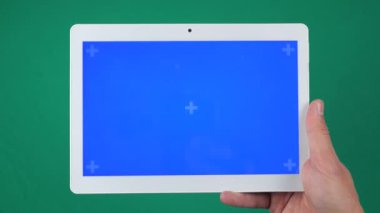 Eldeki yatay tablet yeşil arkaplanda izole edilmiş. Tablet ekran mavi krom anahtardır, arkaplanda başka bir krom anahtar yeşil ekran vardır.