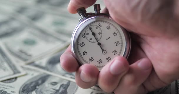 Männliche Hand startet eine Stoppuhr auf Geld Dollar Hintergrund. Zeit ist Geld. Fristkonzept. — Stockvideo
