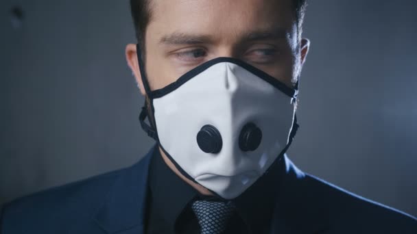 コロナウイルスcovid-19流行中の医療マスクを身に着けているスーツのビジネスマンのクローズアップポートレート. — ストック動画
