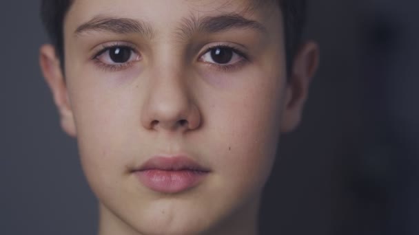 Primer plano de la cara de lindo niño de 10 edades mirando a la cámara en casa por la noche — Vídeo de stock