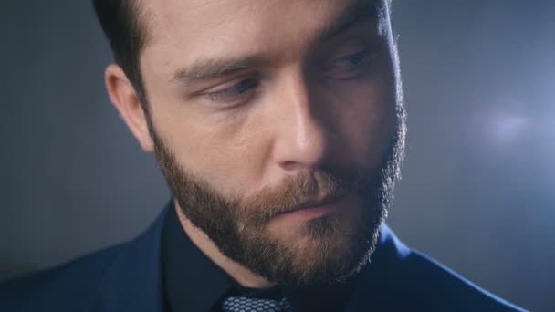 Портрет серйозного бізнесмена з бородою, що дивиться на камеру. Крупним планом впевнений бос в чорному костюмі — стокове відео