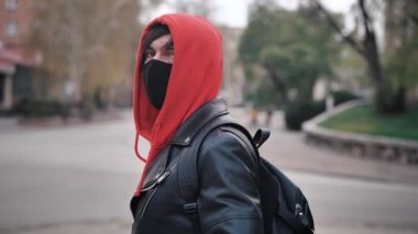 Açık havada duran koruyucu maskeli genç bir adamın portresi, ülkede mevsimsel grip salgını.