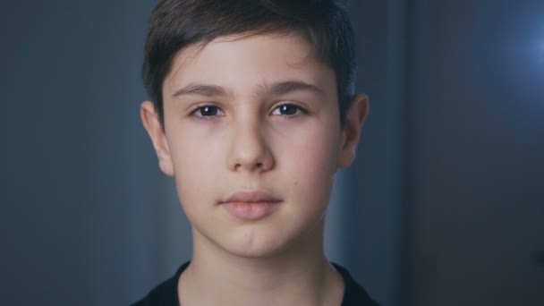 Portrait de mignon garçon de 11 ans regardant la caméra à la maison le soir — Video