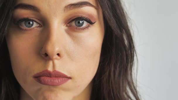 Close-up portret van schoonheid jong mooi vrouwen blauw ogen kijken naar camera. — Stockvideo