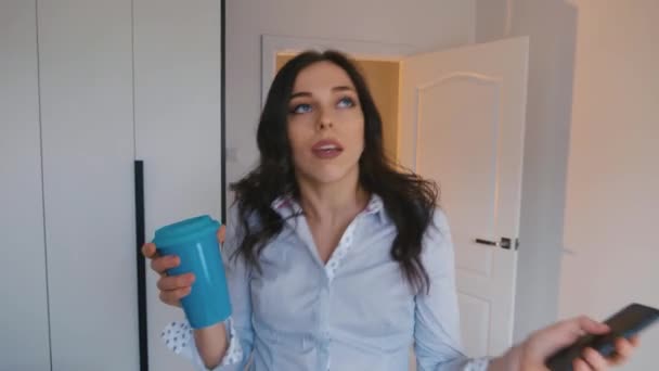 Heureuse jeune femme d'affaires qui s'amuse à utiliser un smartphone, boire du café et danser au bureau — Video