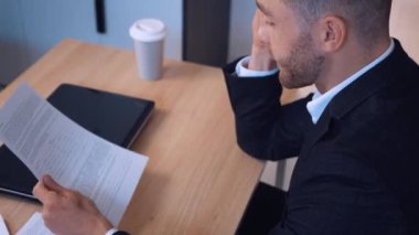 Pozitif girişimci işadamı ev ofisinde cep telefonundan duygusal olarak bahsediyor. Telefonla iş görüşmesi, iş akışı.