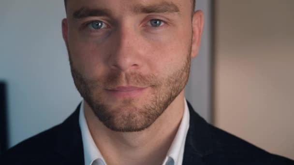 Portrait de beau jeune homme d'affaires avec une barbe regardant la caméra. Gros plan du visage . — Video