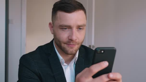 Důvěryhodný podnikatel ve formálním obleku sedí u svého stolu v kanceláři domů pomocí Smartphone, Procházení přes internet, Sociální média. — Stock video