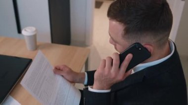 Pozitif girişimci işadamı ev ofisinde cep telefonundan duygusal olarak bahsediyor. Telefonla iş görüşmesi, iş akışı.