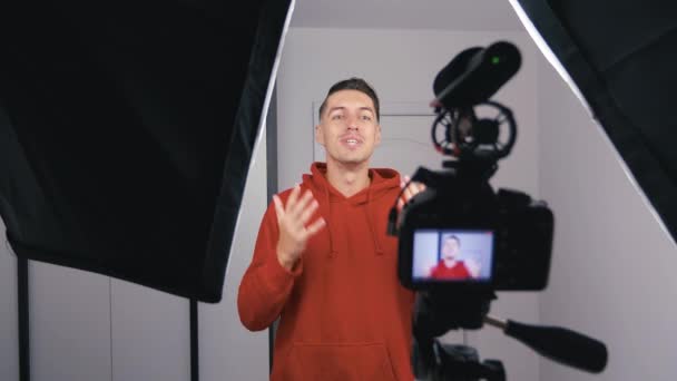 Щасливий молодий блогер знімає нове відео у відеоблозі з професійною камерою вдома — стокове відео