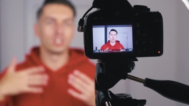 Zbliżenie blogger lub vlogger man nagrywania nowego vlog wideo z profesjonalną kamerą w domu. Skup się na kamerze.. — Wideo stockowe