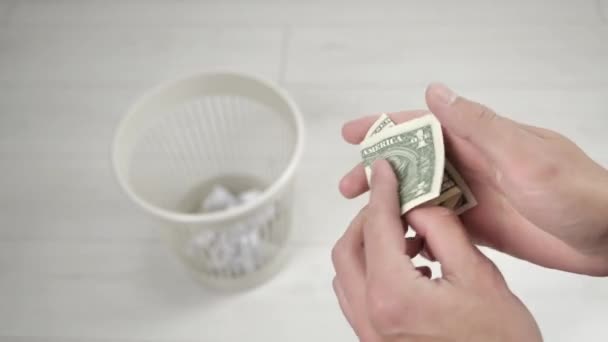Τα αρσενικά δίνουν ένα χαρτονόμισμα και το πετάνε στον κάδο. Ανακύκλωση χρημάτων. Κοντινό πλάνο. — Αρχείο Βίντεο