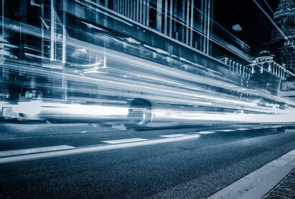 blurred traffic light trails on road with cityscape