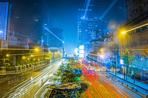 blurred traffic light trails on road at night in China.