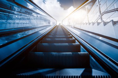 Bir metro istasyonu içinde yürüyen merdiven arka planda manzarası ile.