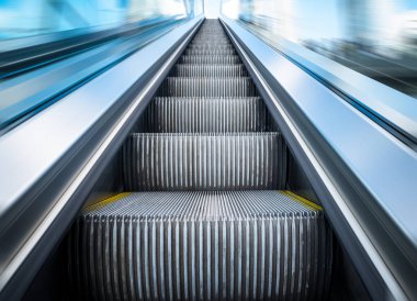 Mavi tonu bir metro istasyonunda yürüyen merdiven.