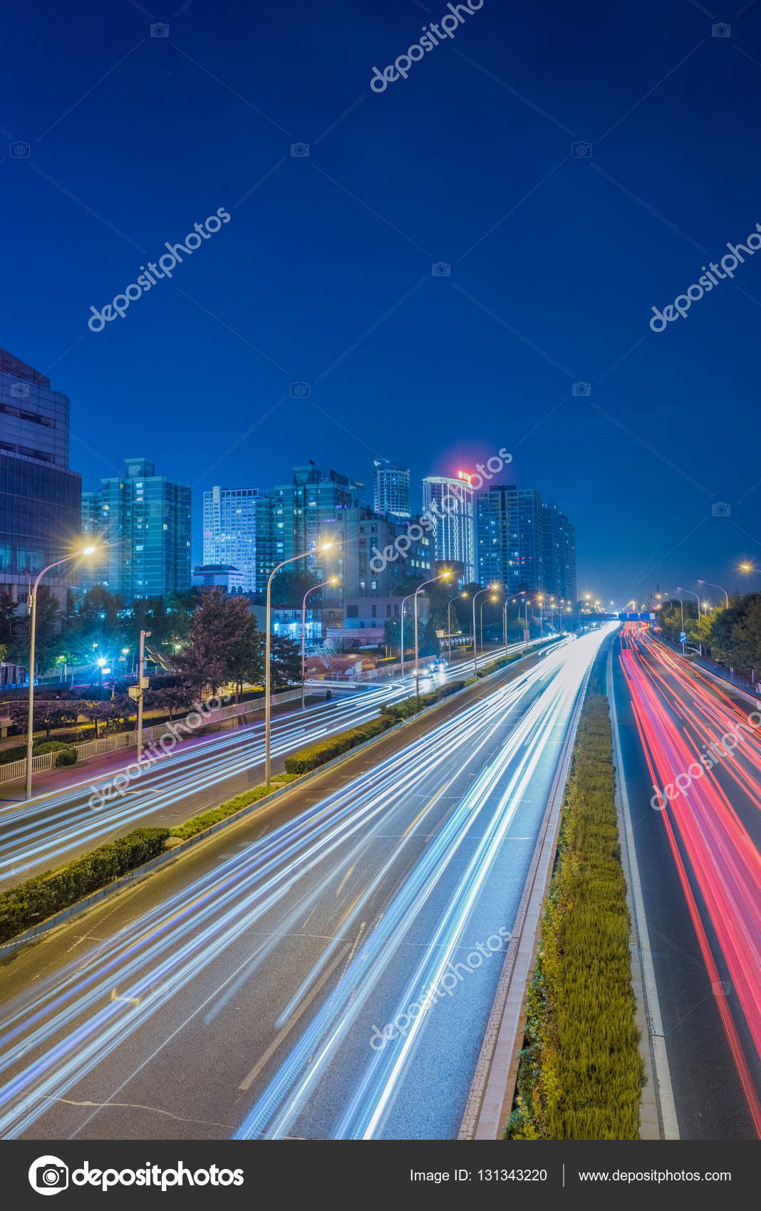 Los senderos difuminados del semáforo en la carretera por la noche en China  . — Foto de stock #131343220 © fanjianhua, image size:1068x1700