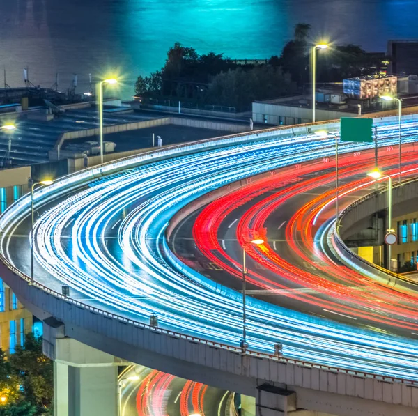 blurred traffic light trails on road at night