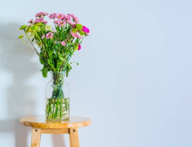 Yakın çekim, pembe çiçek içinde cam vazo masada