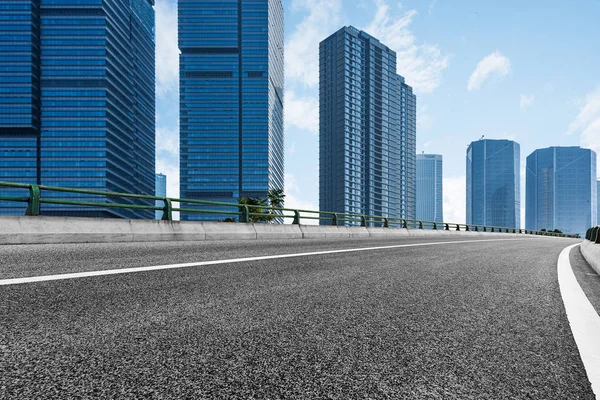 Prázdné asfaltové silnici přes moderní město — Stock fotografie