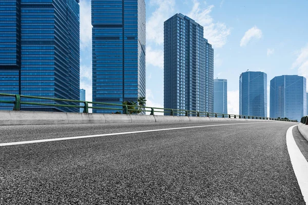 Empty asphalt road through modern city — Stock Photo, Image