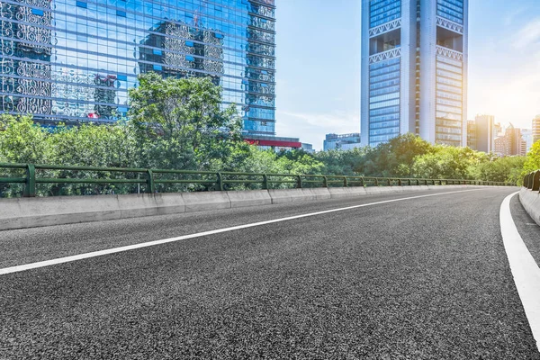 Empty asphalt road through modern city — Stock Photo, Image