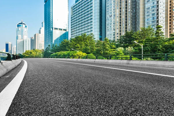 Empty urban road through modern city — Stock Photo, Image