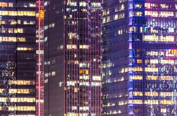 Fachada de highrises modernos iluminados à noite — Fotografia de Stock
