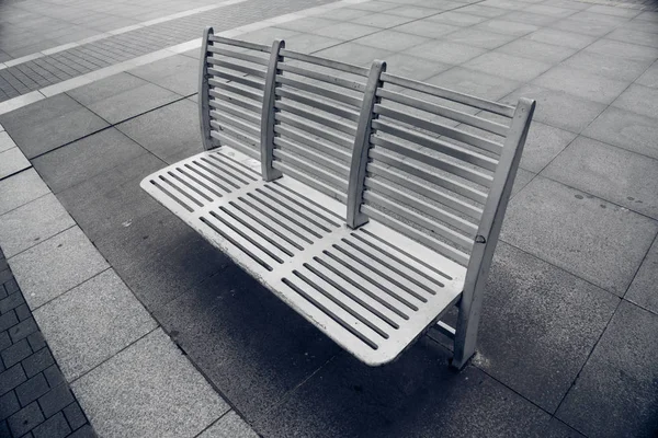 Banco vacío en el pavimento en la ciudad — Foto de Stock