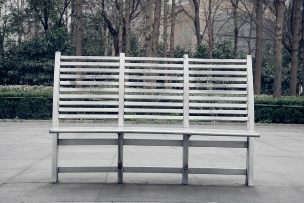 Panchina vuota sul marciapiede in città — Foto Stock