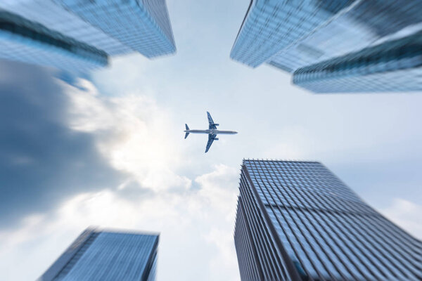 Low angle view of business buildings with flying plane in Shenzhen,China.