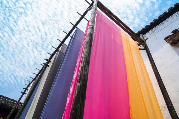 Tela colorida que cuelga para secar después del proceso tradicional del tinte — Foto de Stock