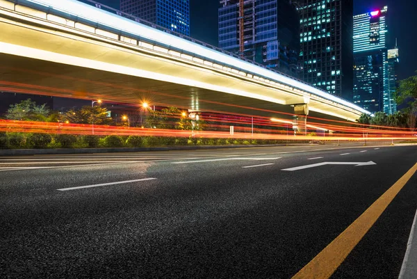 Estrada de tráfego urbano com paisagem urbana à noite — Fotografia de Stock