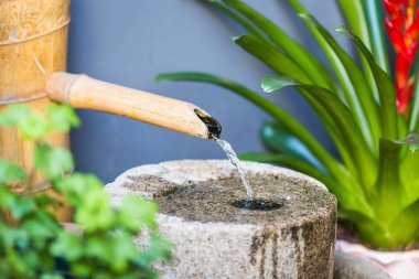 Bambu yan görünüm emzik taş üzerine su dökerek