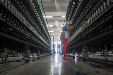 kadın işçi iş parçacığı yapma makinesi pamuk fabrikası içinde yanında ayakta