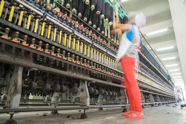 Женщина-работница, стоящая рядом с машиной для изготовления нитей внутри хлопковой фабрики — стоковое фото