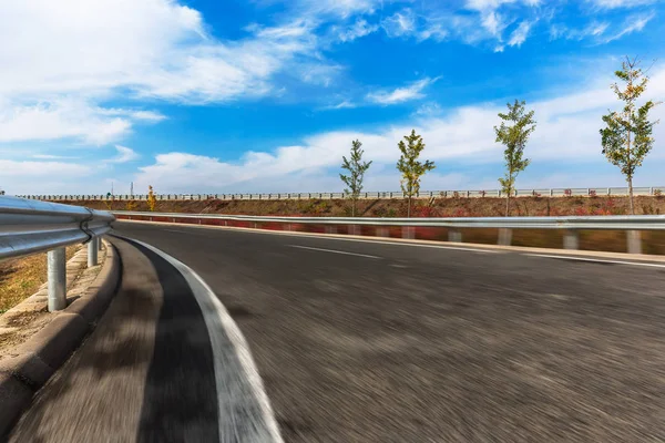 Autopista moderna a través de montañas contra el cielo — Foto de Stock