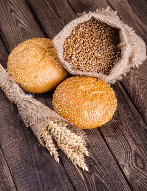 Ahşap masa arkasında pişmiş ekmek çeşitleri