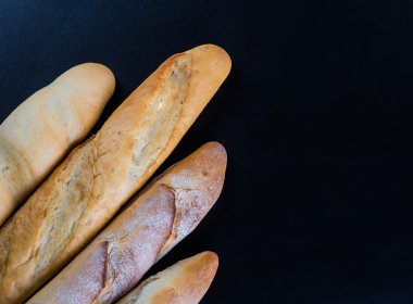 Ahşap masa arkasında pişmiş ekmek çeşitleri