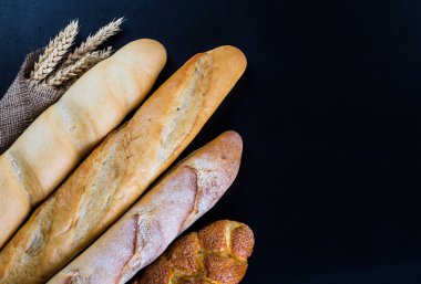 Ahşap masa arkasında pişmiş ekmek çeşitleri