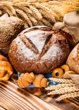 Ahşap masa arkasında pişmiş ekmek çeşitleri