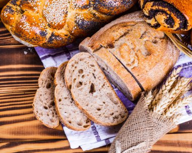 Ahşap masa arkasında pişmiş ekmek çeşitleri