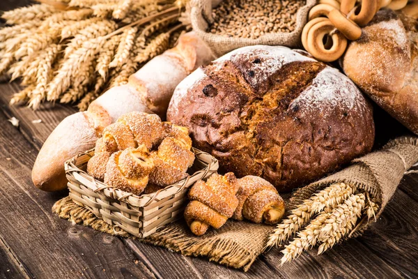 Assortment of baked bread on wooden table background — Stock Photo, Image
