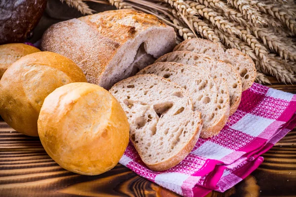 Assortment of baked bread on wooden table background — Stock Photo, Image