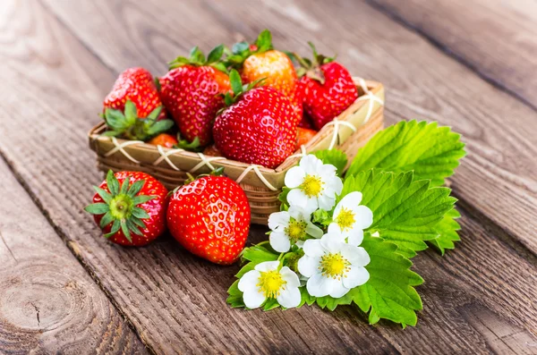 Strawberry on wood background. Strawberry with green leaves flow — Stock Photo, Image