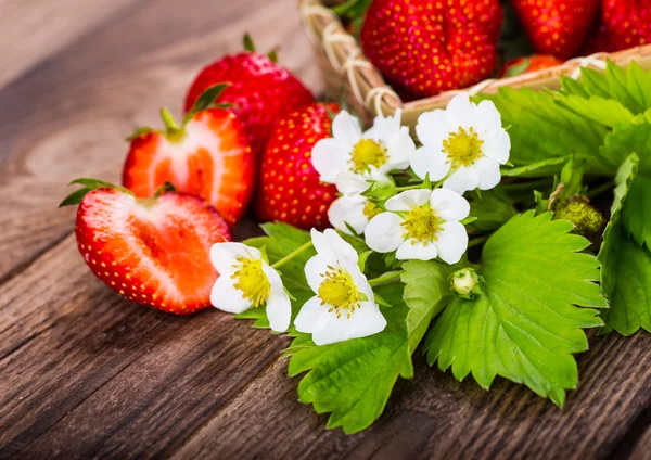 Strawberry on wood background. Strawberry with green leaves flow — Stock Photo, Image