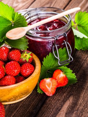 Çilek ahşap arka plan üzerinde. Çilek yeşil yaprakları akışı ile