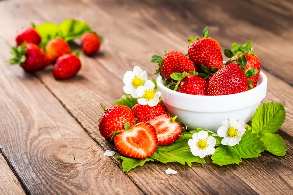 Strawberry on wood background. Strawberry with green leaves flow — Stock Photo, Image